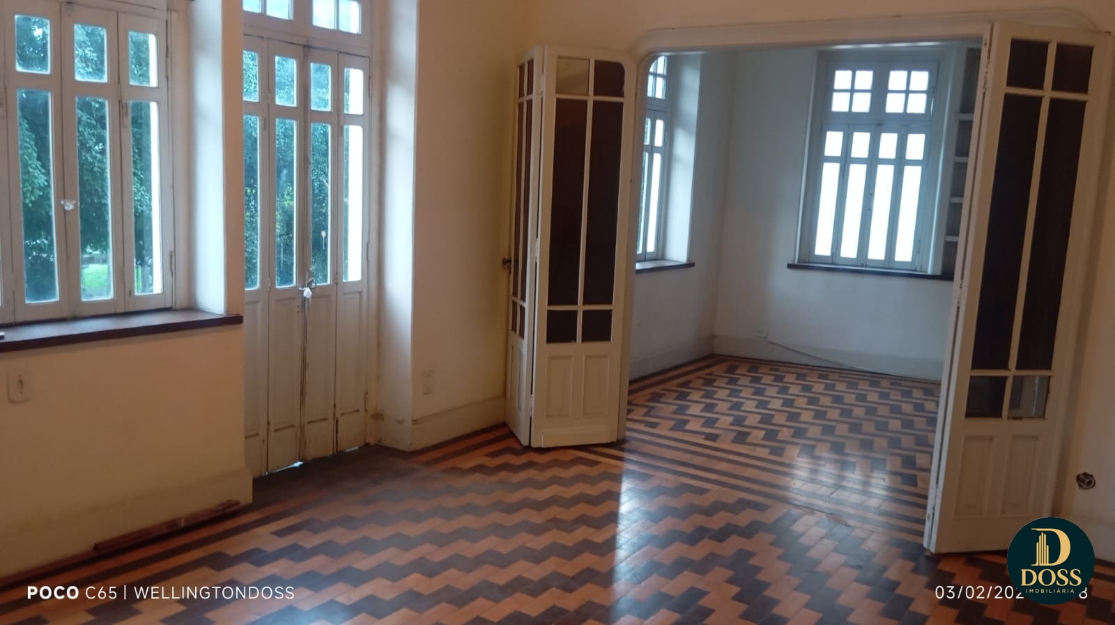 Sala com janelas amplas e piso original